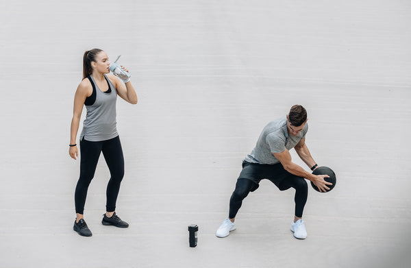 two people exercising drinking water